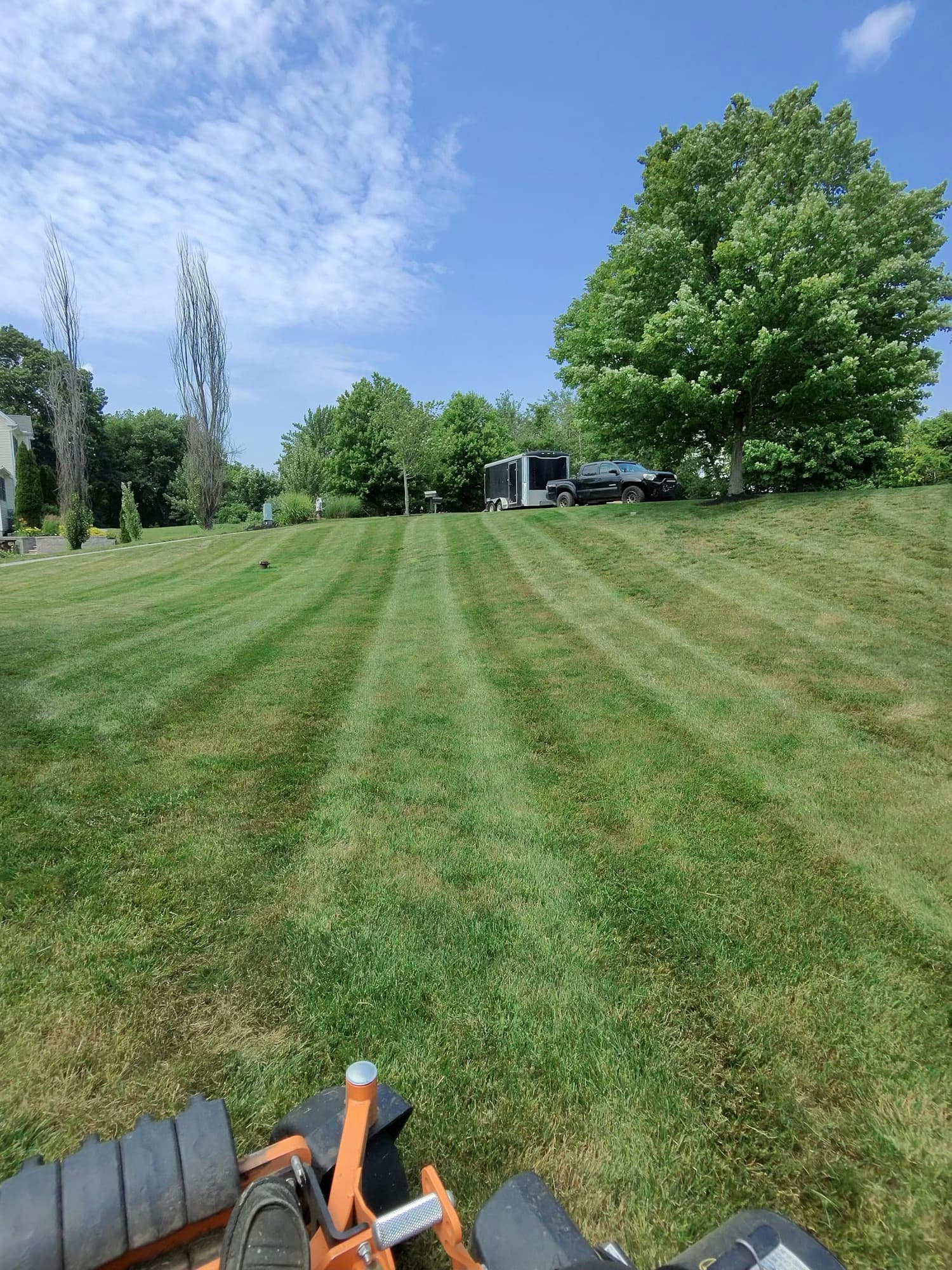 Grass Roots truck and trailer parked atop a freshly mowed hill
