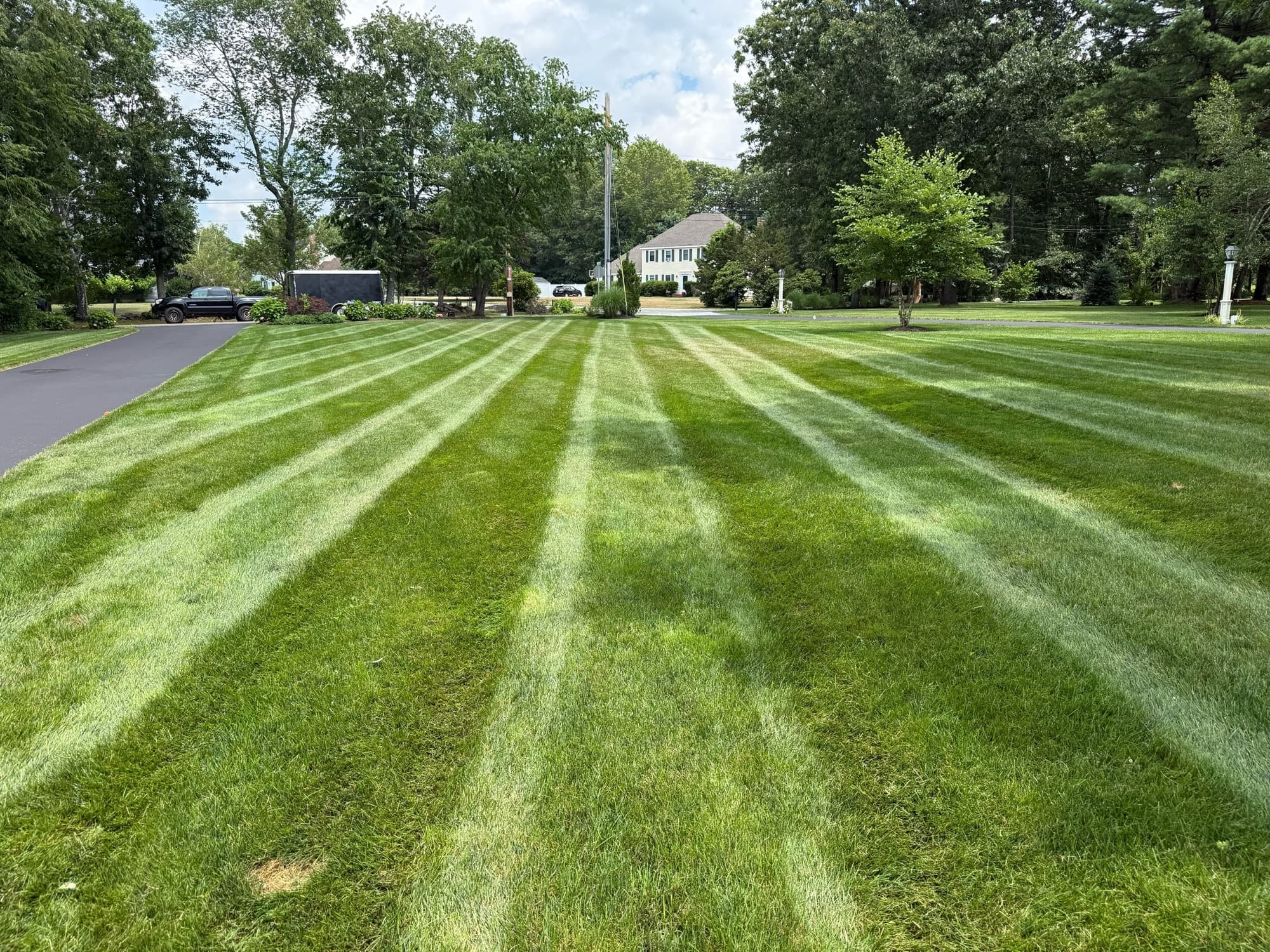 Freshly striped lawn with the Grass Roots trailer in the distance